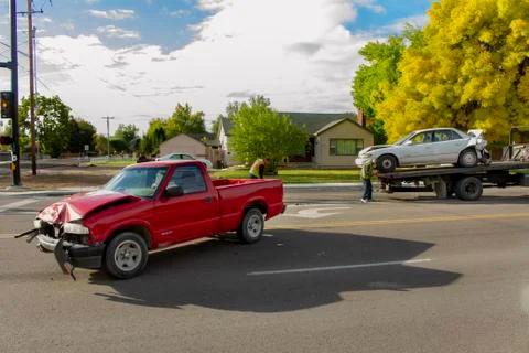 Car on a flat bed while the car that caused the accident is up front Stock Photos