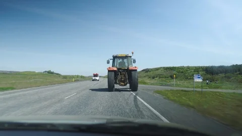 In a car following an old tractor driving on a road, Then driving past Stock Footage