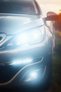 Car front view with glowing headlights Stock Photos