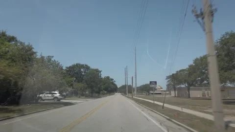 Car Front Window View Of Road In Florida City on a sunny day. Stock Footage 240684101
