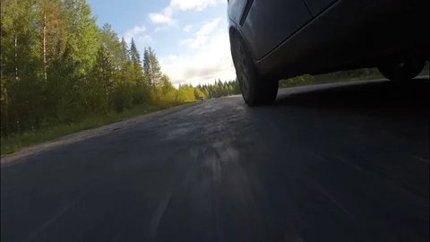 The car goes on the road passing through the forest. Stock Footage 70153901