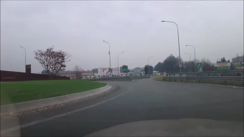 Car going around a traffic circle and onto the highway Stock Footage 295449867