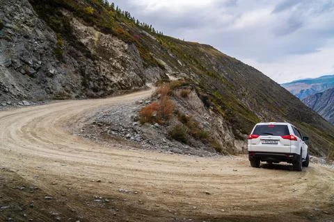 Car going down mountain road from Katu-Yaryk pass to valley of Chulyshman River Stock Photos