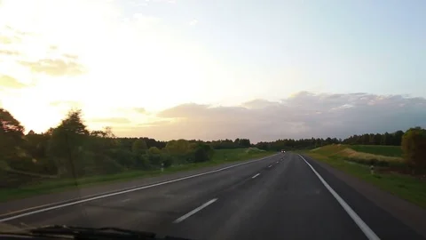 The car is going down the road at sunset 스톡 동영상 76564582