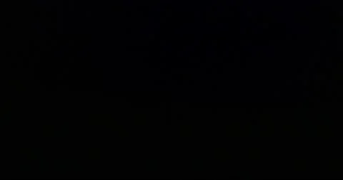 Car going on a road at the base of a mountain in the dark while out lightnin Stock Footage 171062249