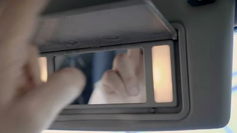 In car the hand pulls down the sun visor, it also has an illuminated mirror Video stock 138285929
