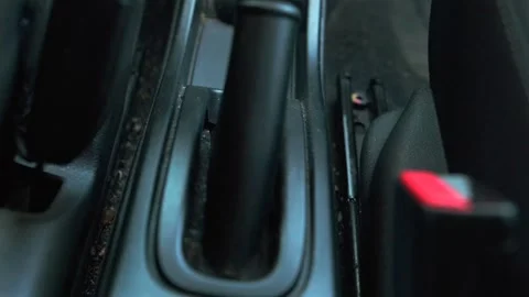 Car handbrake engaging close-up interior shot showing parking brake lever being Stock Footage 333617594