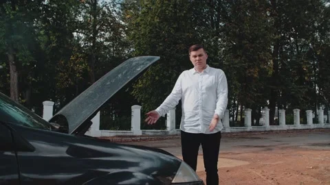 The car has broken down, the man makes a helpless gesture, Stock Footage 150121594