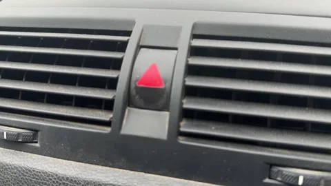 Car hazard warning signal blinking on dashboard button near air vent, vehicle Stock Footage 337120710