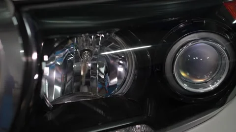 Car headlight assembly featuring a projector lens and reflector housing. Stock Footage 344597984