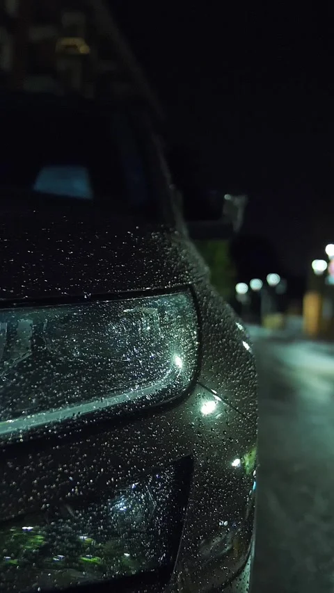 Car headlight in raindrops. Rain in the city. Submerged road. Night. Raindrops. Stock Footage 316780845