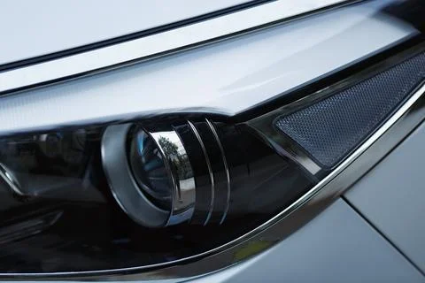 A car headlight with a sleek design, featuring chrome elements, a lens for fo Fotos de archivo