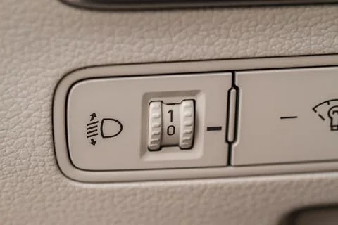 Car headlights corrector adjustment button. Close up view of the modern car i Stock Photos