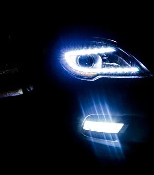 Car headlights on a dark background. Stock Photos
