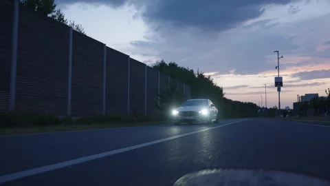 Car with headlights on dark empty road Stock Footage 346262463