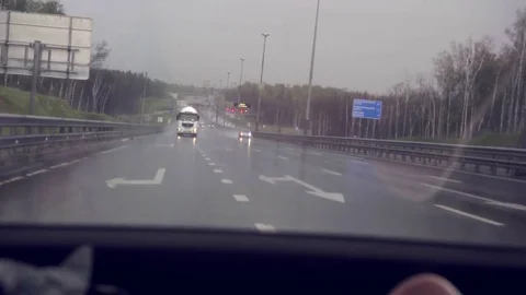 A car with headlights on goes after another car on the highway. Back view Stock Footage 78603573