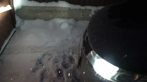 Car headlights lighting falling snow in the evening Stock Footage 146549925