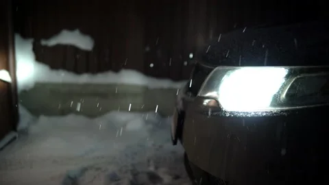 Car headlights lighting falling snow in the evening Stock Footage 146550305