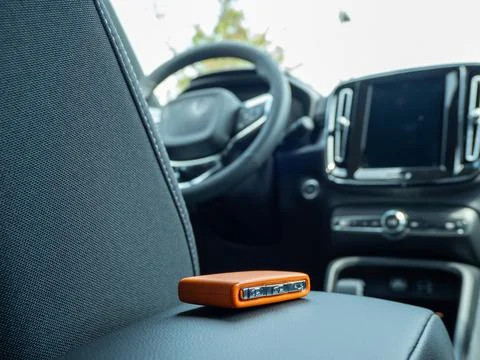 Car ignition key on the armrest in the interior of a modern car. Stock Photos