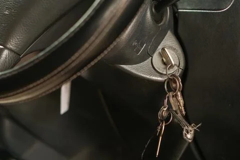 Car ignition key inserted in the switch inside a vehicle cabin 库存照片