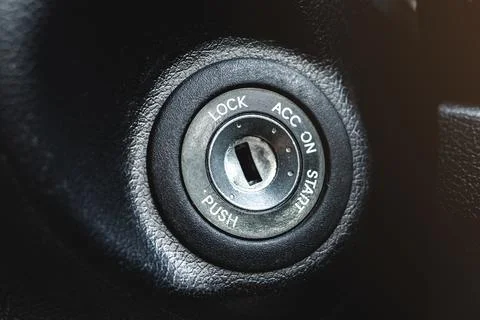 Car ignition lock under the steering wheel in a black interior Stock Photos
