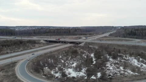 A car interchange with an overpass on a cloudy spring evening in the woods Stock Footage 151886346