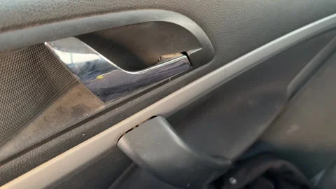 Car interior door handle is pulled as the door opens and closes, close-up of Stock Footage 337114041