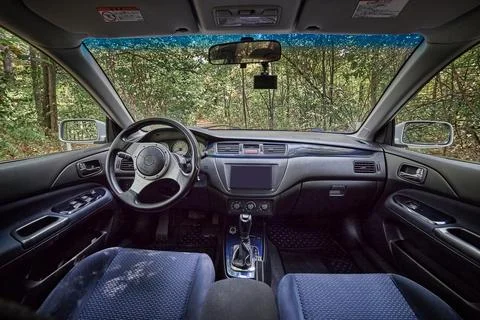 Car interior with forest view through windshield Stock Photos