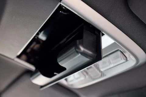 Car interior overhead console with open sunglasses holder, glowing map lights Stock Photos