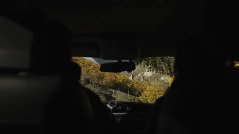 Car interior silhouette frames winding rural road and rolling hills Stock Footage 327013602