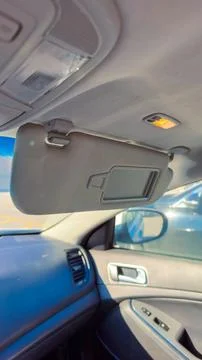 Car interior with sun visor down and light on showing reflection of rear vi.. Foto stock