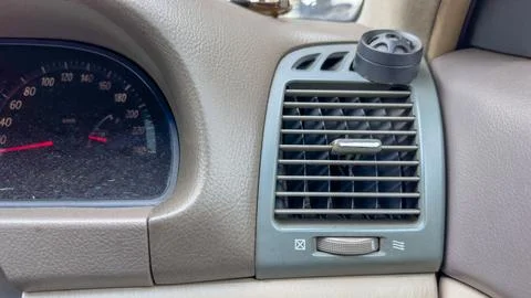 Car interior view shows vent with knob and textured dashboard in neutral tone Stock Photos
