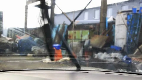 Car interior view, windshield wipers clean glass, industrial landscape blur Video stock 329213998
