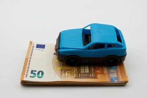 Car isolated on a stack of euro banknotes. Costs of traveling concept. Stock Photos