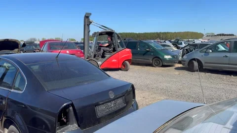 Car junkyard with forklift transporting old vehicle for recycling and disposal. Stock Footage 308013653