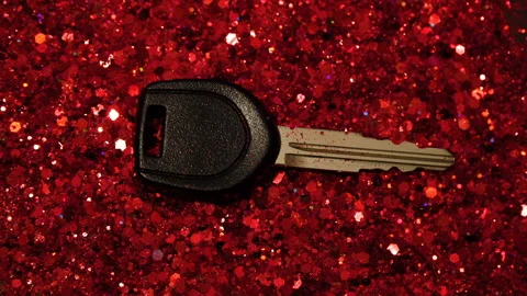 Car key against the background of red glitter Stock Footage 99991271