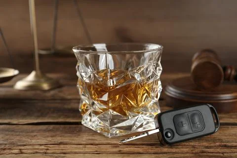 Car key, glass of alcohol near gavel on wooden table. Dangerous drinking and  Stock Photos