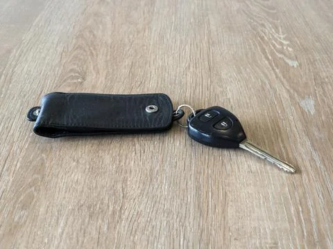 Car key include remote control and keychain on wood table Stock Photos