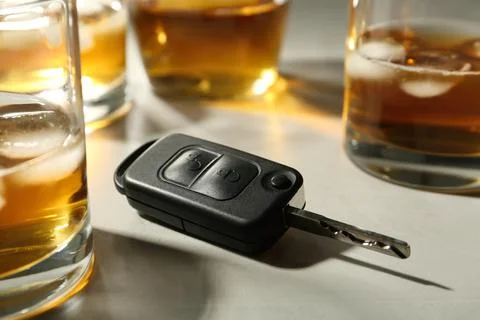 Car key near glasses of alcohol on table. Dangerous drinking and driving Stock Photos