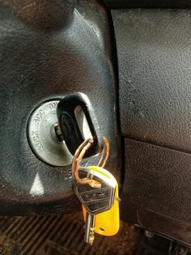 Car key in on position with yellow key ring accessory Stock Photos