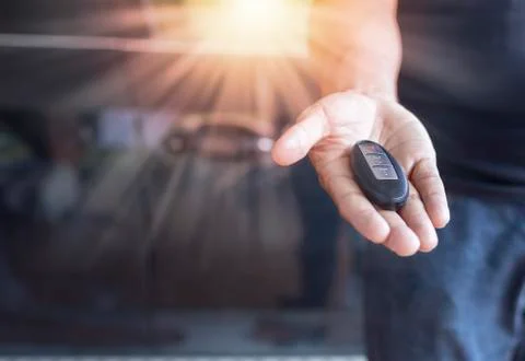 Car key remote on hand. Hand man giving a car remote. Stock Photos