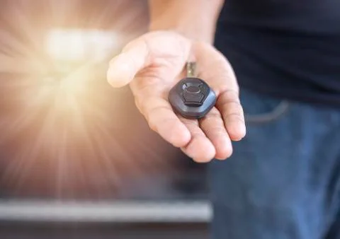 Car key remote on hand. Hand man giving a car key. Stock Photos