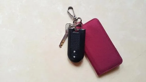 Car key remote with red canvas wallet on marble granite background Stock Photos