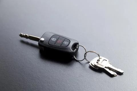 Car key on top of a black table with natural light. Key with buttons to lock  Foto stock