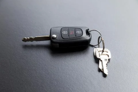 Car key on top of a black table with natural light. Key with buttons to lock  스톡 사진