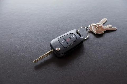 Car key on top of a black table with natural light. Key with buttons to lock  Stock Photos