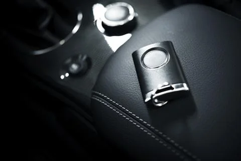 Car keys and remote control laying on car armrest Fotos de archivo
