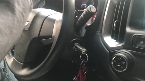 CAR KEYS DANGLING UNDERNETAH STEERING WHEEL OF CAR WHILE DRIVING Stock Footage 161088477