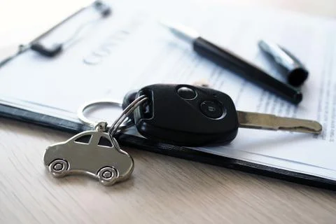 Car keys placed on contract documents about car loans. Foto stock