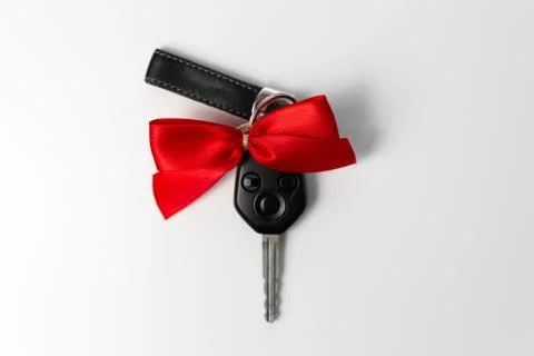 Car keys with red bow as present on white background. New car gift concept Stock Photos
